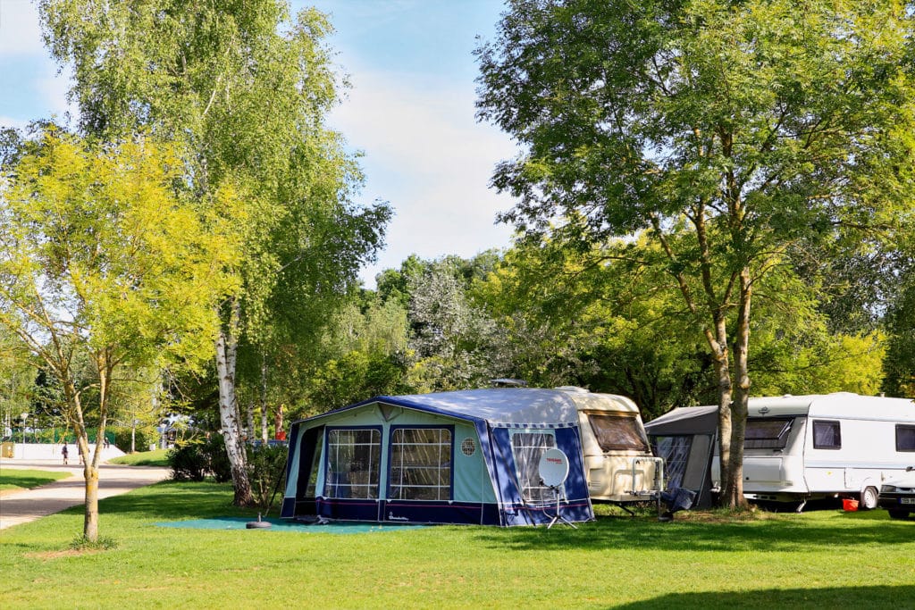 Emplacement tente dans un camping au Lac d’Orient, sol herbeux et ombragé